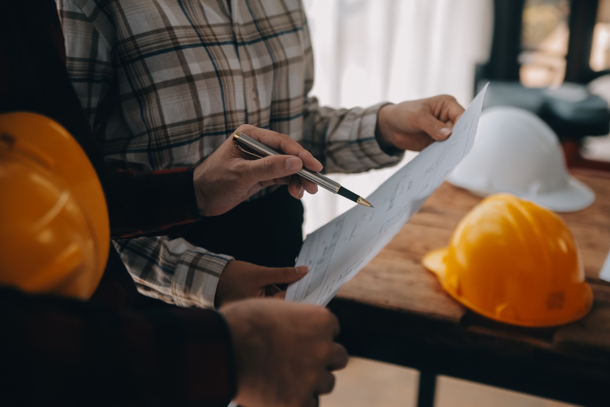 Byggherre noterer på et planark under et byggeprosjekt